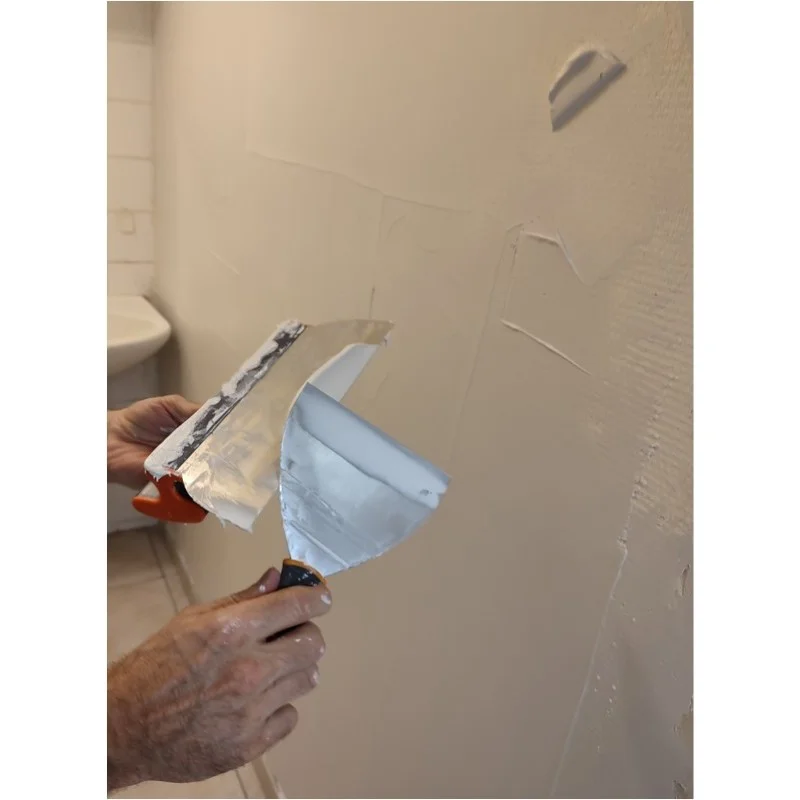Application d'un enduit de lissage sur un mur ancien