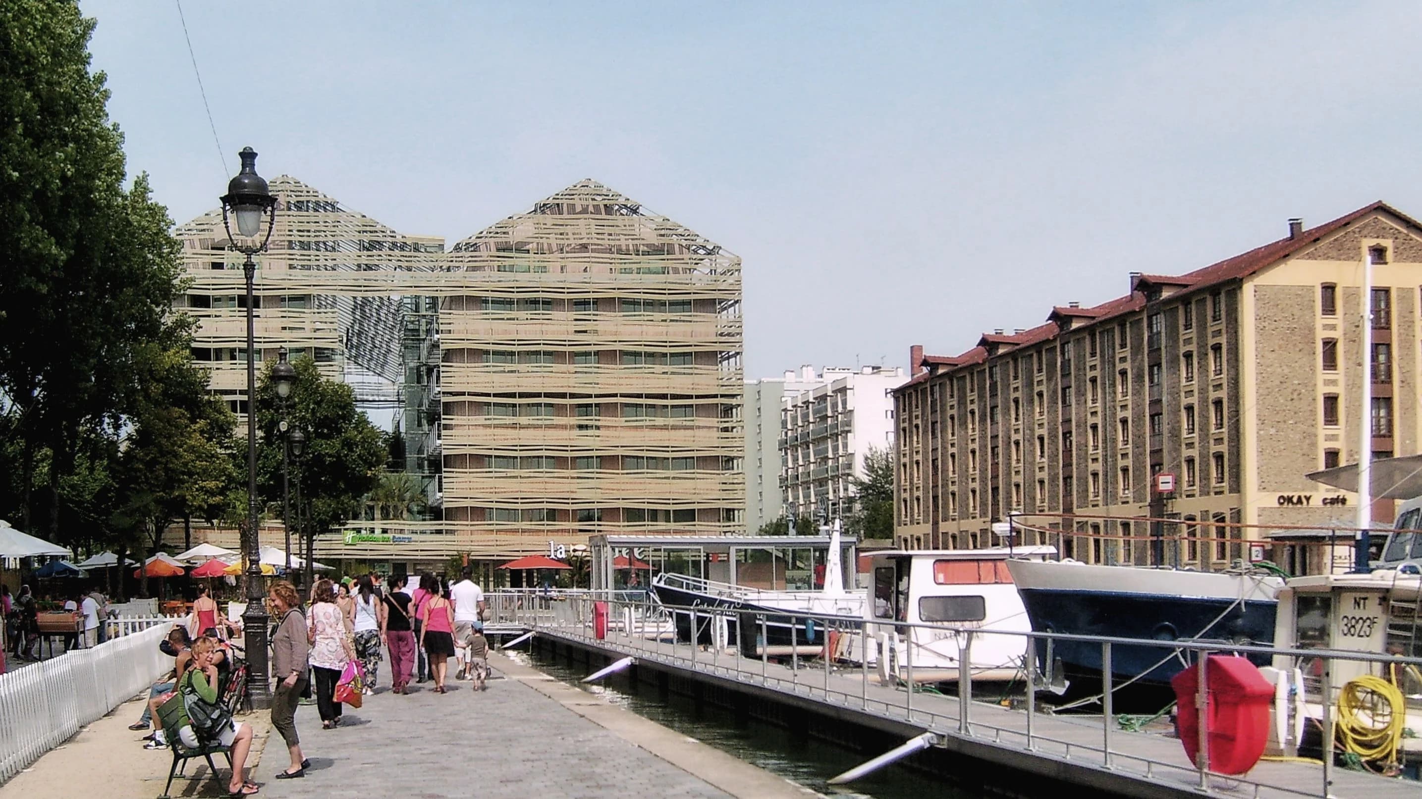 Promenade au bord d'un canal parisien bordée d'immeubles
